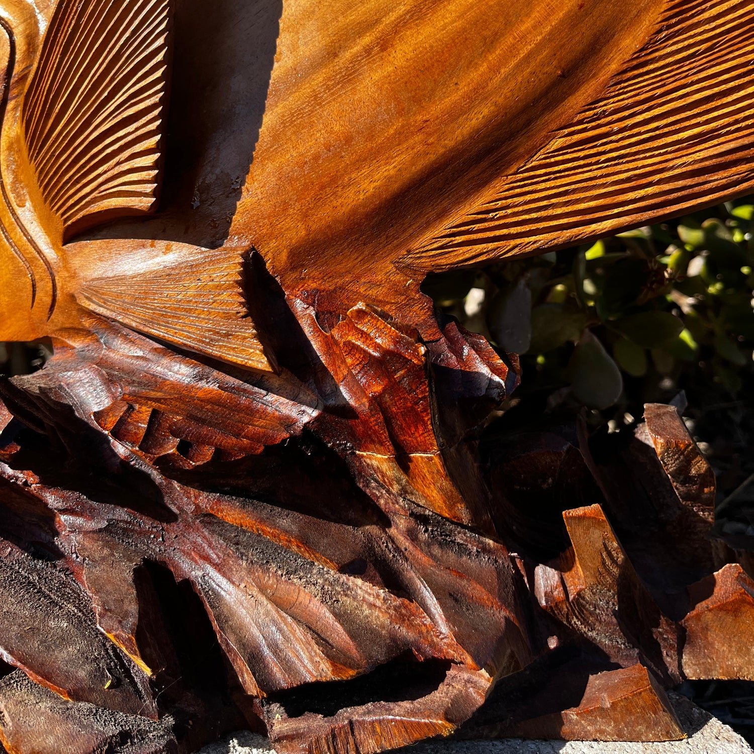 A detailed view of the hand-carved wooden coral reef base, highlighting the intricate textures and craftsmanship. Made from mahogany wood, set against a natural background.