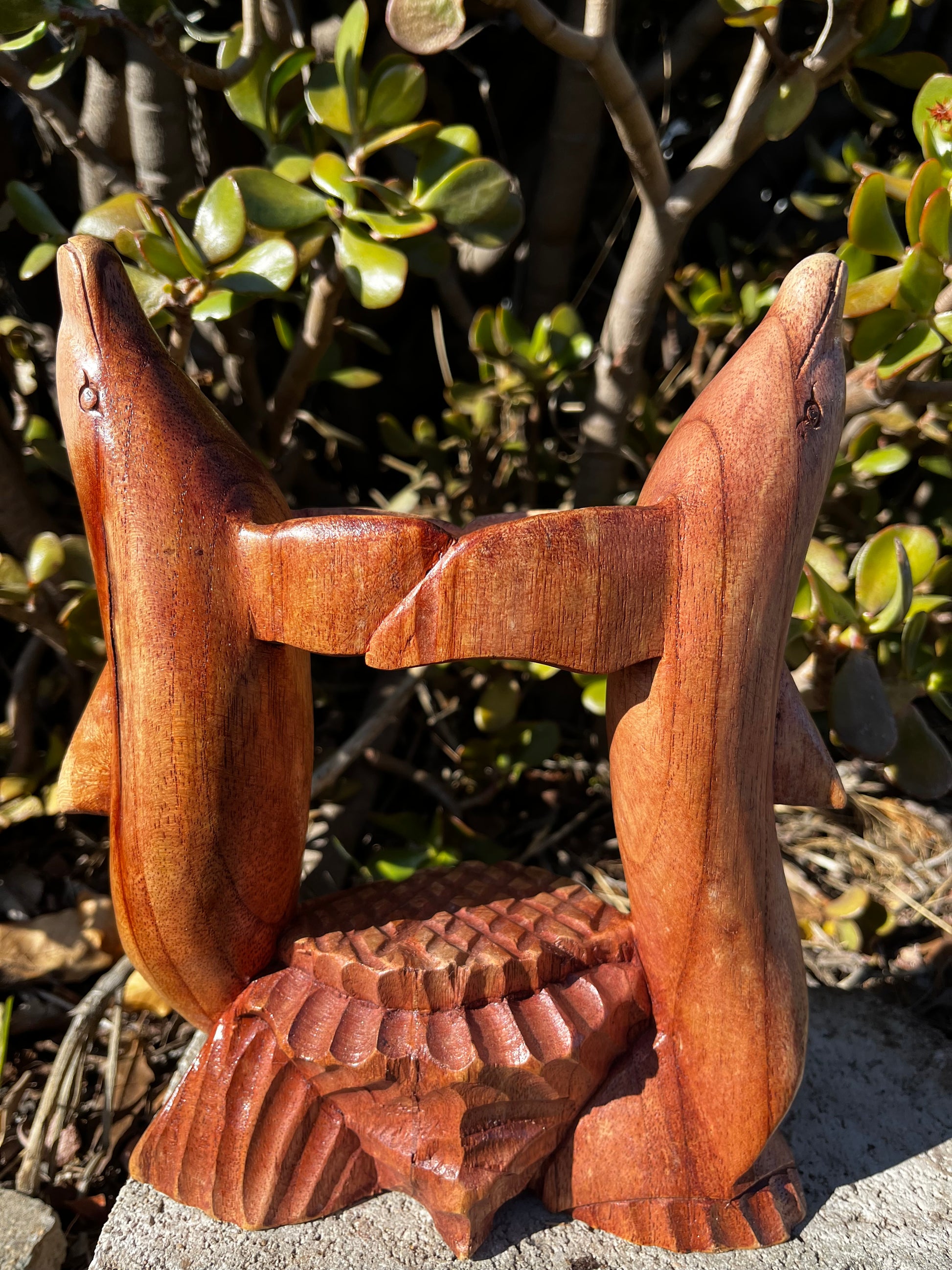 A beautifully hand-carved wooden dolphin hugging a loving beer bottle or can holder. This unique piece showcases intricate detailing of the dolphins' curves, adding a whimsical and ocean-inspired touch to your home. Crafted from high-quality wood, it makes a perfect statement piece for any room or beach-themed décor.