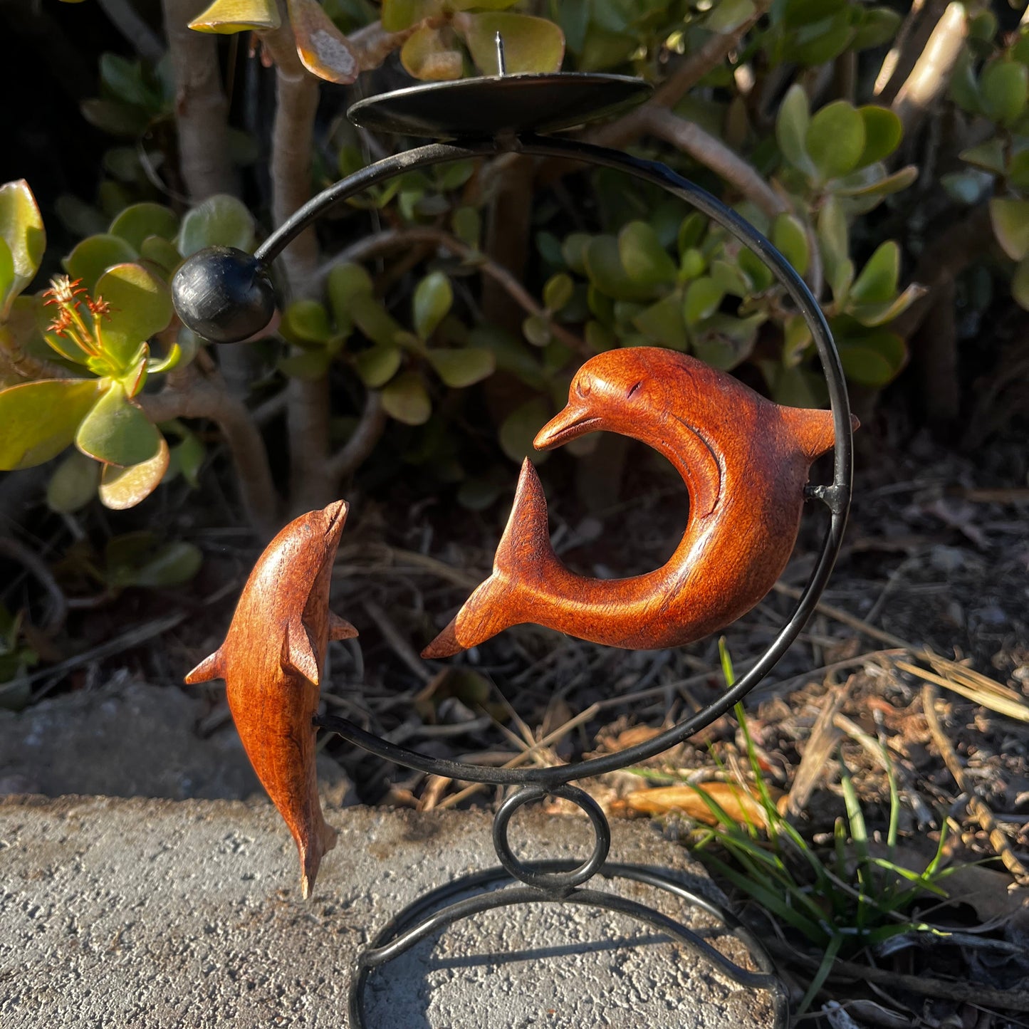 Handcrafted dolphin candle holder, featuring a unique design, shown against a nature-inspired background