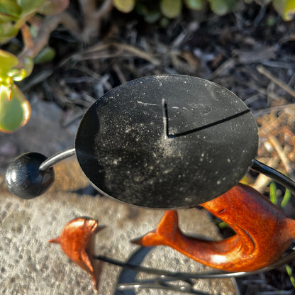 Handcrafted dolphin candle holder with candle stick display, featuring a unique design, shown against a nature-inspired background. 