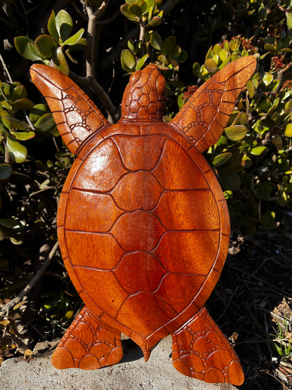 A beautifully crafted wooden turtle wall plaque, hand-carved from mahogany wood with intricate details. Showcased against a natural background, perfect for ocean-themed decor.
