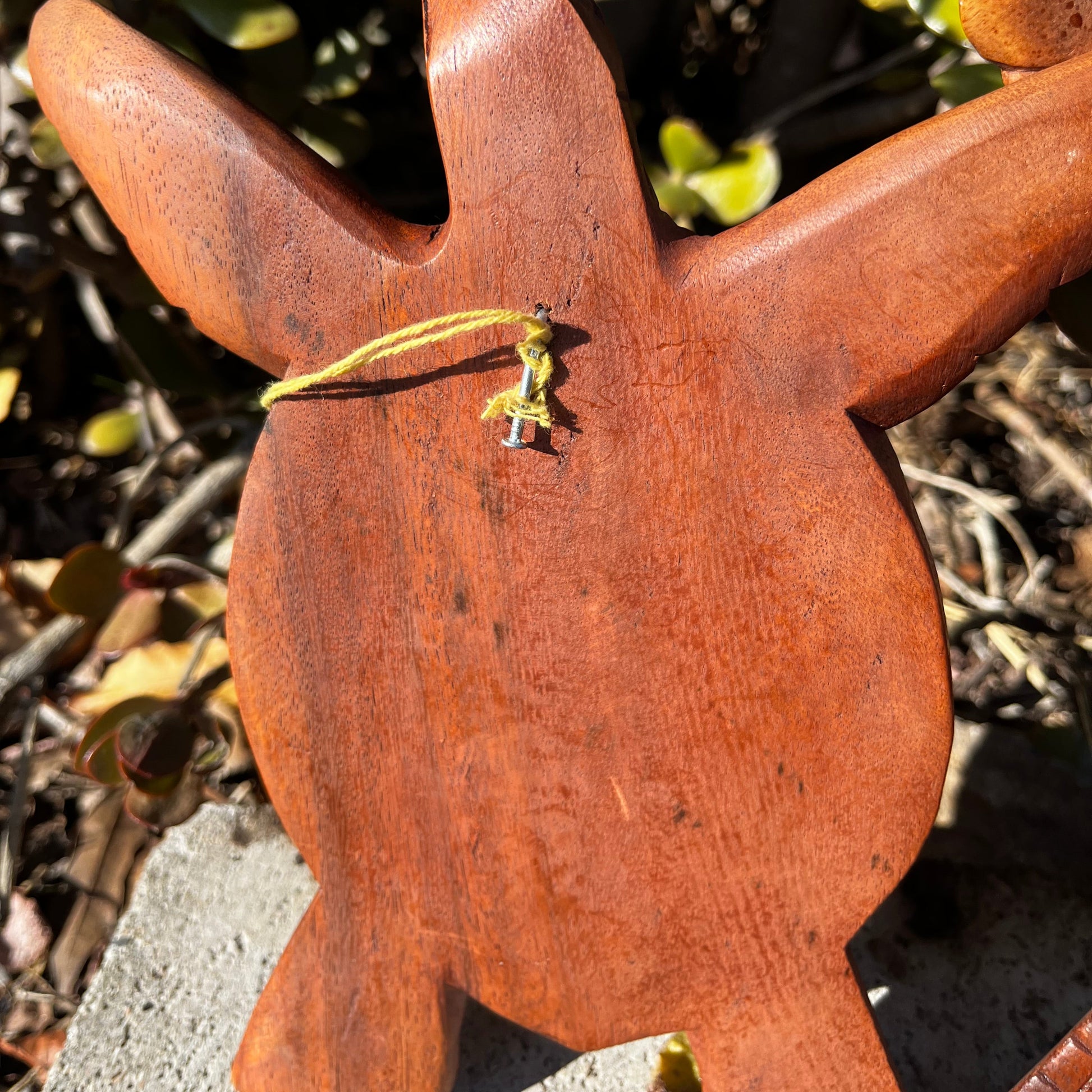 A close-up view of the sturdy hook on the back of the hand-carved wooden turtle wall plaque, designed for seamless wall mounting.