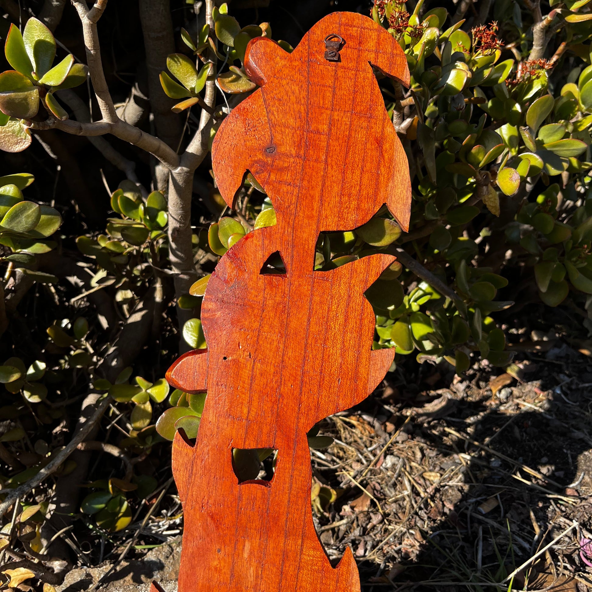 Back view of a hand-carved wooden turtle wall plaque featuring three turtles. Shows the smooth mahogany wood finish and the attached hook for easy wall mounting